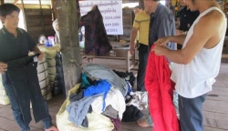 2016_05⑦ボリカムサイ県パッカディン地区　ベール梱包を開けて衣料品を確認しているようす